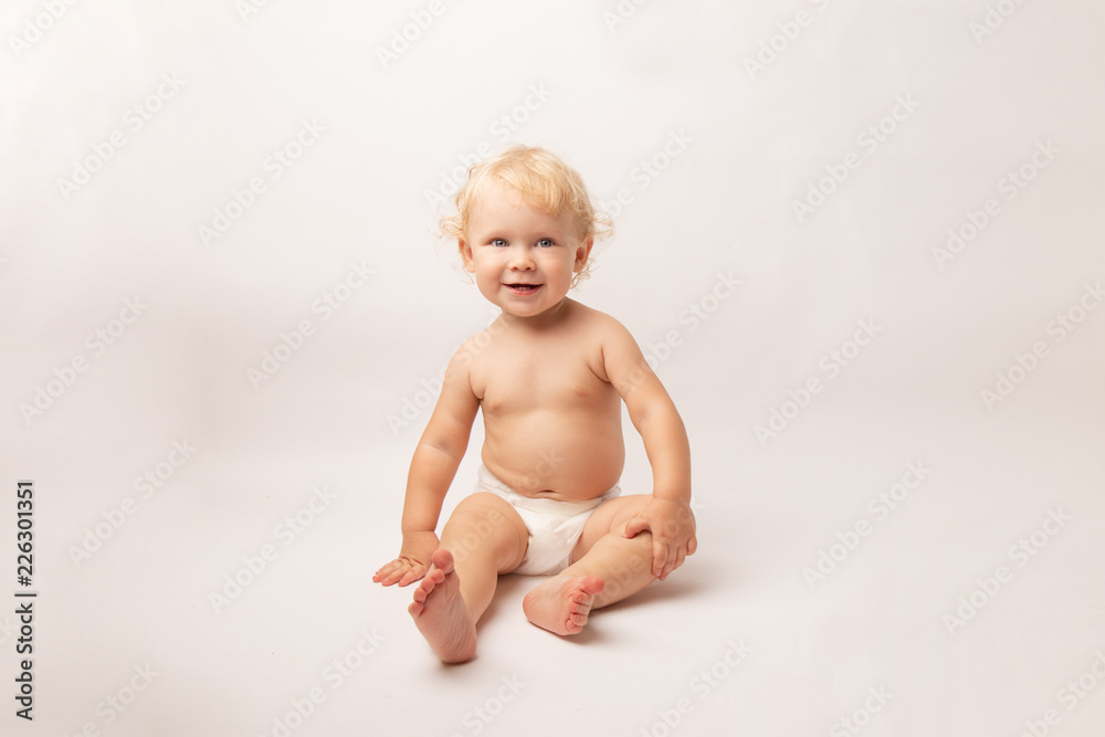 Infant child baby girl in diaper laughs happy looking at the camera isolated on a white background Infant child baby girl in diaper laughs happy looking at the camera isolated on a white background