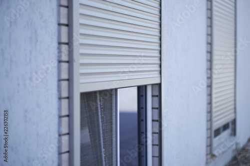 Window with half-closed roller shutter, closeup