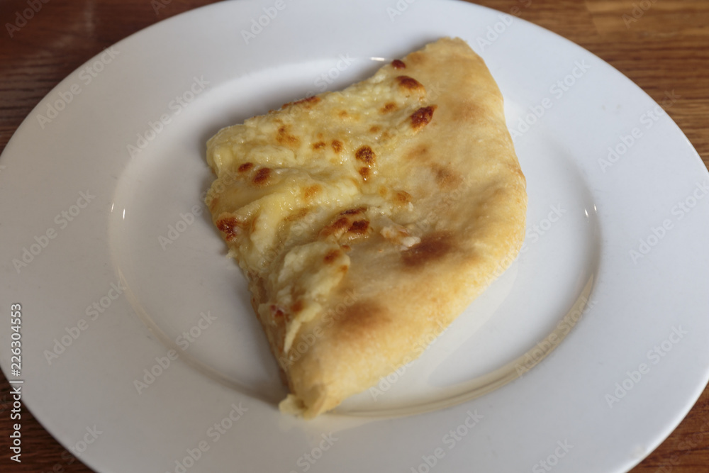 Fresh cheese pizza on a plate, Italian and Caucasian traditional appetizer, ready to eat.
