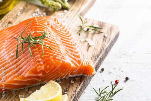 Uncooked salmon fillet with lemon sea salt and rosemary on white