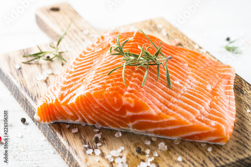 Uncooked salmon fillet with lemon sea salt and rosemary on white