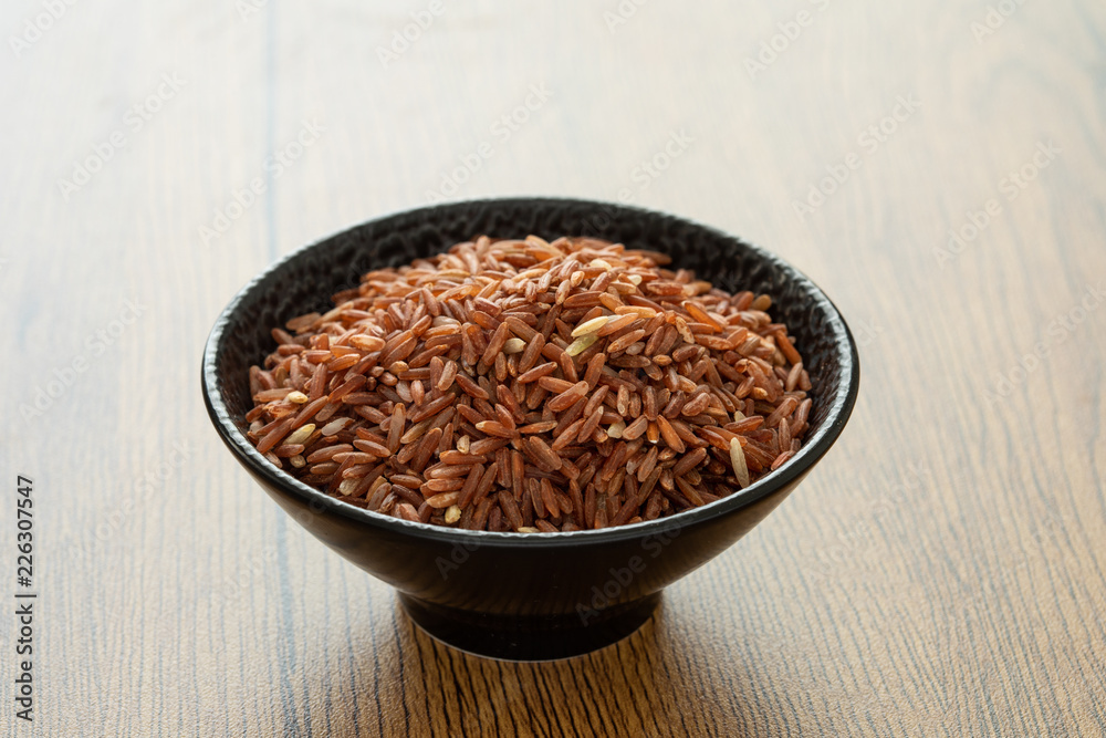 brown rice for healthy black bowl on wood background brown rice for healthy black bowl on wood background