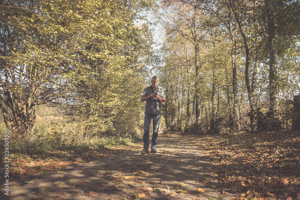 Einsamer Mann auf einem Weg im Wald auf der Suche nach dem richtigen Weg 