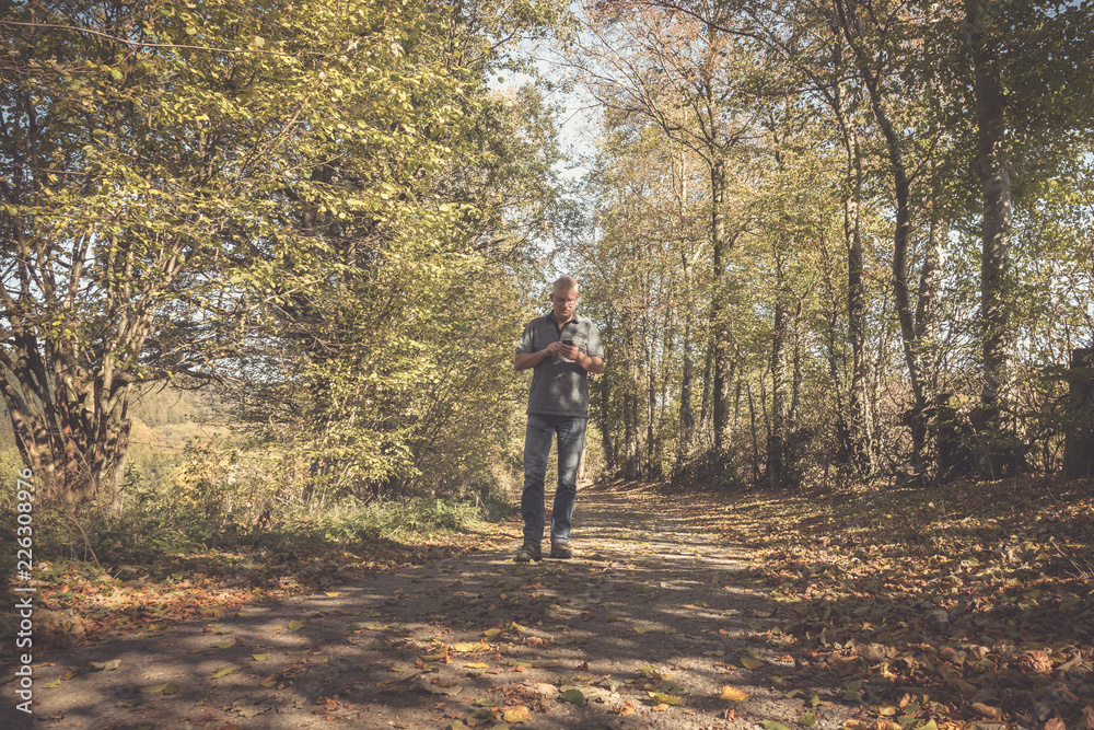 Einsamer Mann auf einem Weg im Wald auf der Suche nach dem richtigen Weg Einsamer Mann auf einem Weg im Wald auf der Suche nach dem richtigen Weg