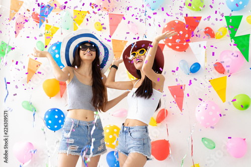 celebration new year or birthday party group of asian young woman and confetti happy,funny concept.drinking wine happy and fun in new year celebrate, color balloon background.
