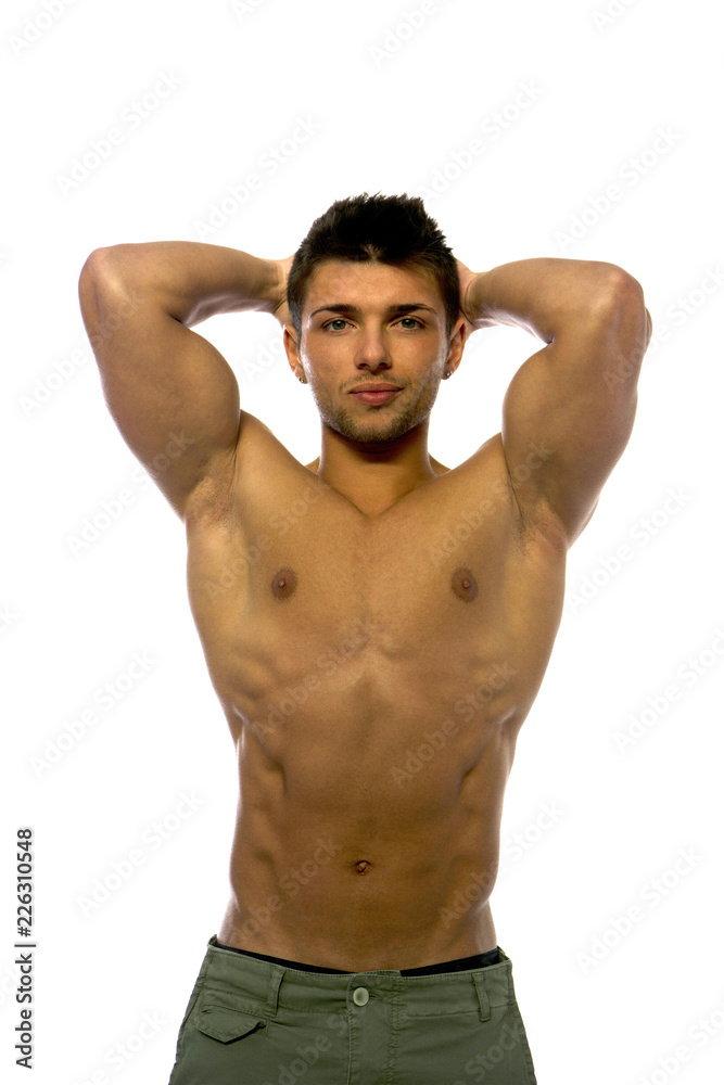 Cute muscular ripped young bodybuilder with hands behind his head, looking away. Isolated on white Cute muscular ripped young bodybuilder with hands behind his head, looking away. Isolated on white