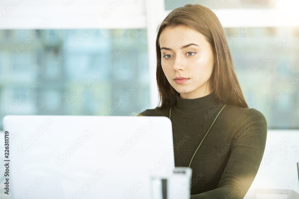 Girl works on a laptop in office