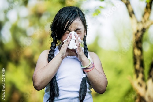 Girl sneezing in park