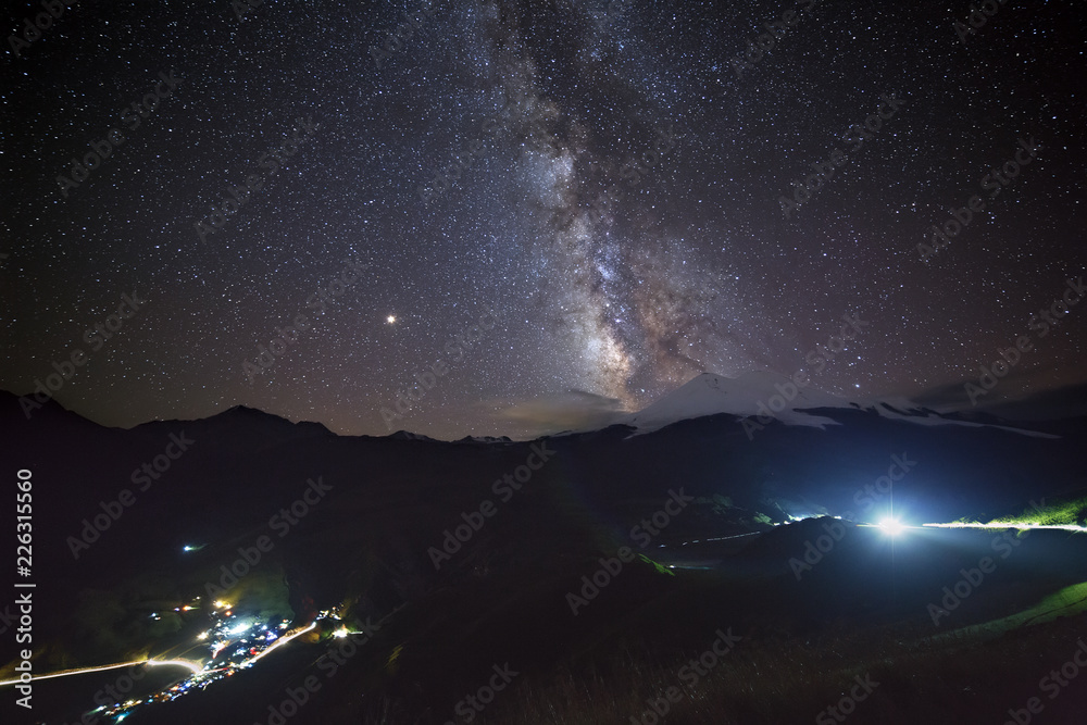 Stars of the Milky Way at night in the sky above Mount Elbrus. View of the northern slope of the two peaks of the stratovolcano. The highest peak of Russia and Europe is 5642m. 