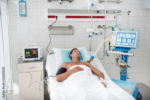 Billede på lærred Portrait of middle aged man on breathing machine sleeping in recovery room after