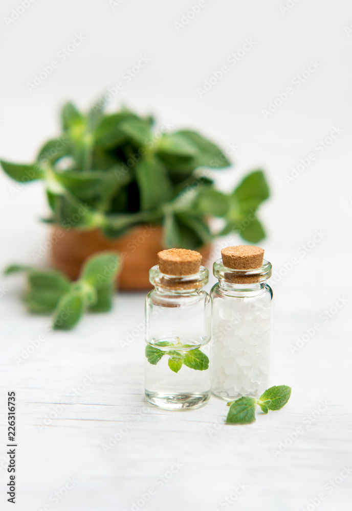 Spa and wellness setting with sea salt, oil essence, jasmin flowers and towels on wooden background. Relax and treatment therapy. Spa and wellness setting with sea salt, oil essence, jasmin flowers and towels on wooden background. Relax and treatment therapy.