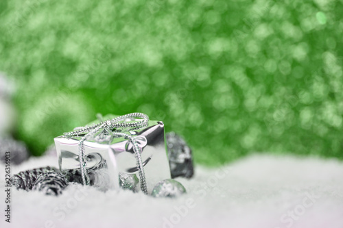 Geschenk auf Schnee vor grünem Hintergrund