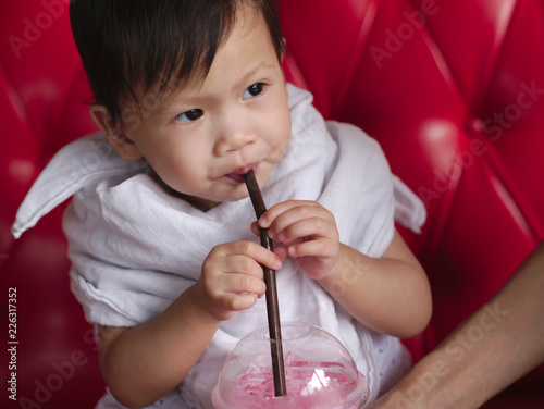 Wallpaper Mural Asian baby drinking iced sweet pink beverage. Torontodigital.ca