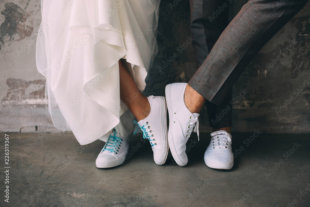 Hipster couple standing together wearing white sneakers. Wedding in sneakers,  love. Soft focus tehnic, wedding style clothes Stock Photo | Adobe Stock