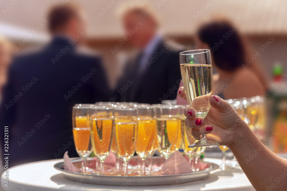 A waitress serves standing glasses filled with champagne and orange juice. Concept: wedding