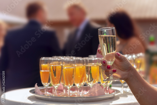 A waitress serves standing glasses filled with champagne and orange juice. Concept  wedding