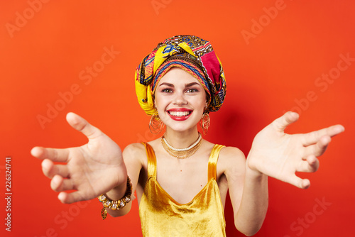 a woman on a color turban stretched out her arms to the camera