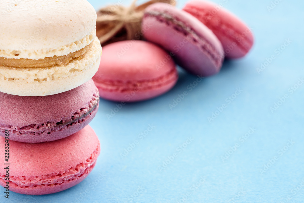 French Macarons on a blue background. Trendy dessert. Sweet cakes. French Macarons on a blue background. Trendy dessert. Sweet cakes.