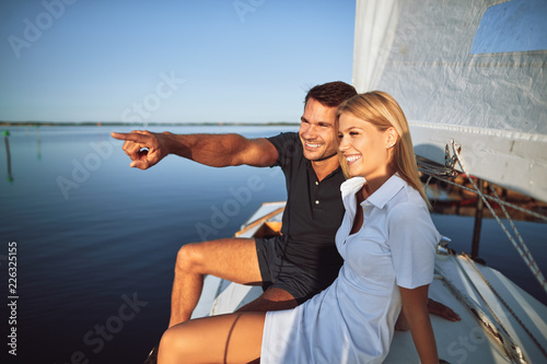 Smiling young couple enjoying the sea views while out sailing © Flamingo Images