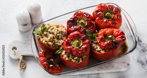 banner of ready baked stuffed peppers in a glass baking dish on white marble table. healthy vegan cuisine for the whole family. comfort food