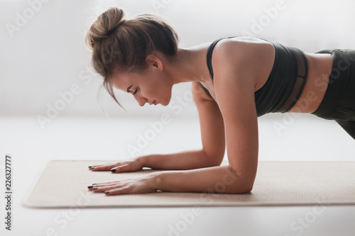 Young woman performing Dolphin Plank exercise