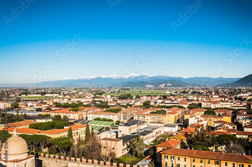 Spectacular view on the Pisa city from the height with mountain peaks and snow on the background