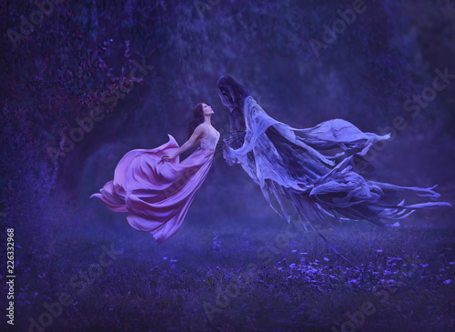 The mysterious witch is dancing with a demon, dark forces, in the air. Kiss dementor. Taking away the soul. A dress waving in the wind during the flight. Harry Potter. Art photo of levitation photo