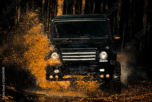 Mud and water splash in off-road racing. Off the road travel on mountain road. Track on mud. Expedition offroader. 4x4 Off-road suv car. Offroad car. Safari. Tires in preparation for race.