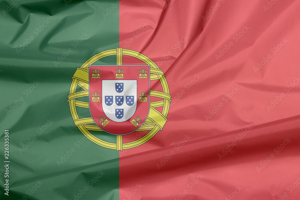 Fabric flag of Portugal. Crease of Portuguese flag background, 2:3 vertically striped bicolor of green and red, with coat of arms of Portugal centred over the color boundary.