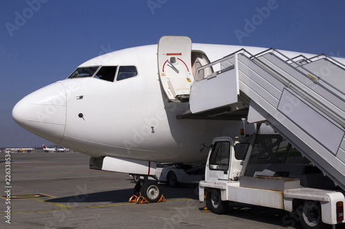 White modern aircraft on the parking zone awaiting service maintenance