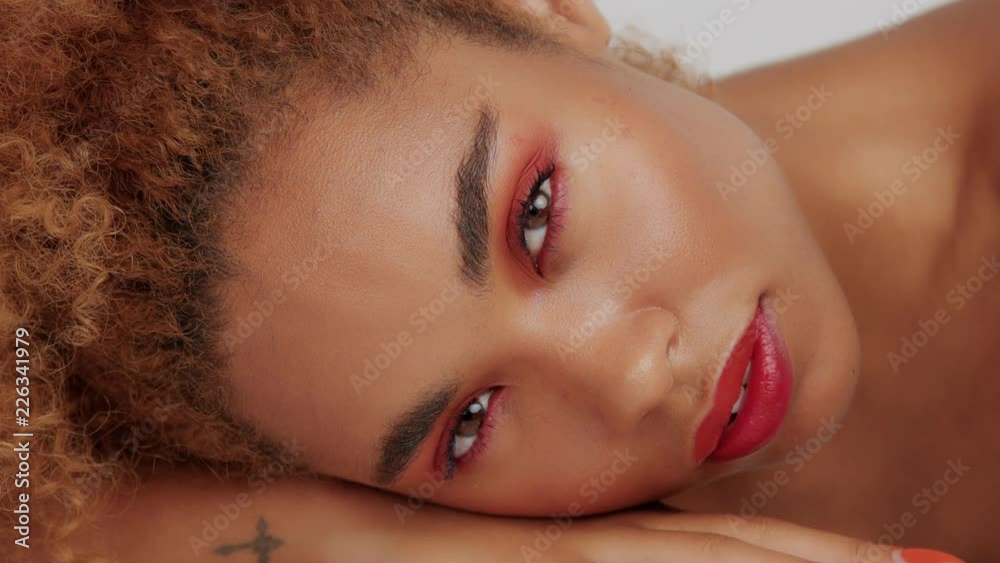 closeup panned video of mixed race woman with red makeup