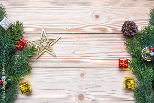 Christmas background with decoration, gift box, Star shape, Bell and pine tree branches on wooden board, Happy New Year and Xmas Holidays banner. Top view and Copy Space for your text