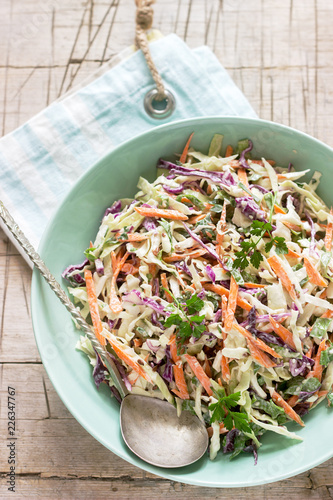 Obraz na płótnie Coleslaw of cabbage, carrots and various herbs with mayonnaise in a large plate on a wooden background. w salonie
