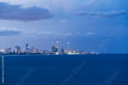 A small bolt of lightning strikes to the north of Surfers Paradise on the Gold Coast, Queensland, Australia. © beau