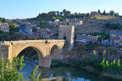 Toledo, Spain - September 24, 2018: People performing extreme sport of Zip Line with the San Martin Bridge in the background in Toledo.
