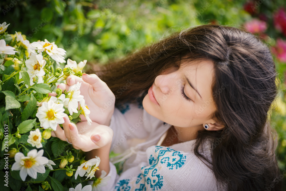 Young beautiful woman smelling flowers in garden. Young beautiful woman smelling flowers in garden.
