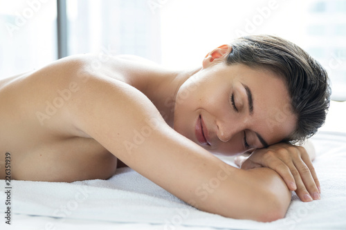 Young and beautiful woman is lying and relaxing after massage