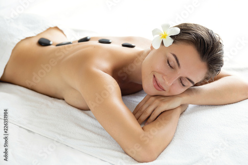Young and beautiful woman during hot stones massage