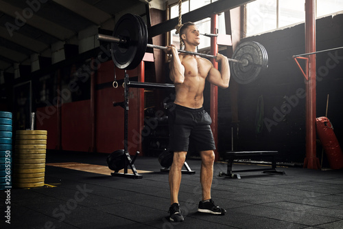 Muscular man during his weightlifting workout in the gym photo
