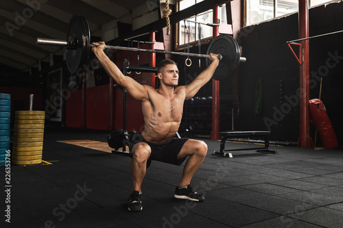 Fotografia Muscular man during his weightlifting workout in the gym
