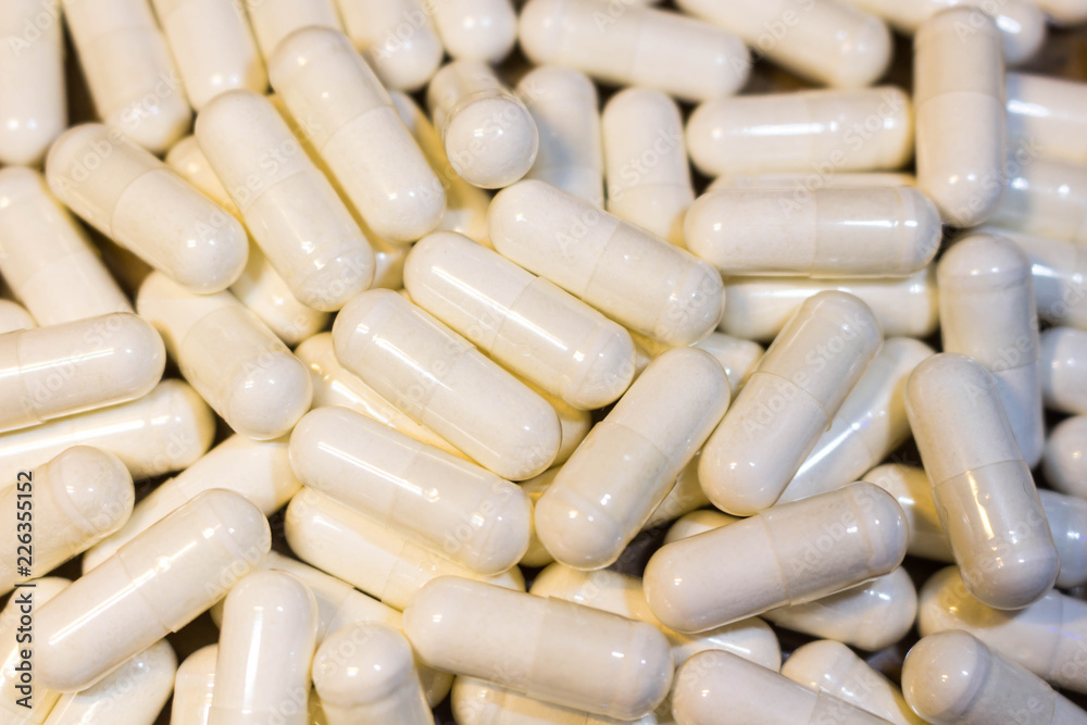 A handful of white pills close-up. Capsules medication is white. A handful of white pills close-up. Capsules medication is white.