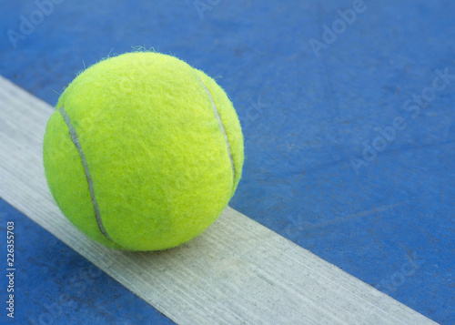 Tennis ball on line in tennis court. © wor_woot