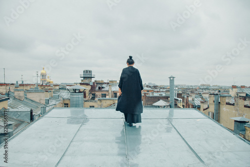 girl in black clothes standing on the edge of the roof