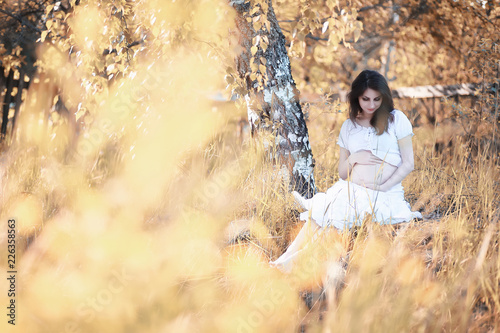 Pregnant woman in nature for a walk in the autumn