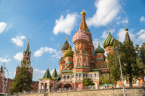 Saint Basils cathedral and Spasskaya tower in Moscow. Famous russian landmarks on blue sky background.