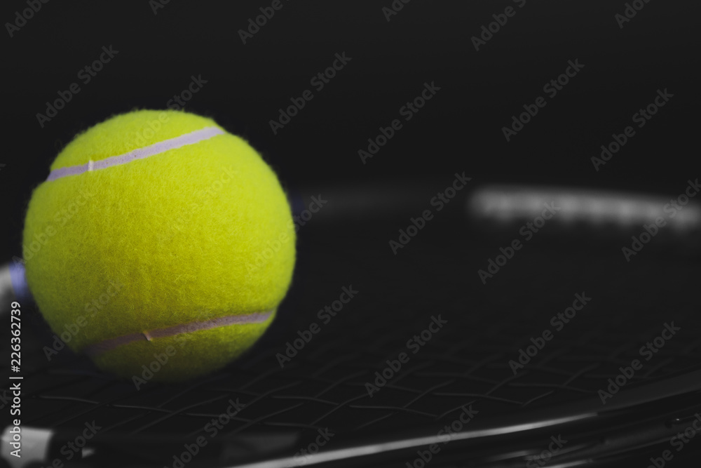 part of new yellow tennis ball on black net racket, copy space on right