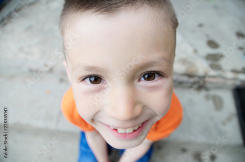 top view boy portrait close-up . Smiling child face. Caucasian kid. fisheye effect. fish-eyed shot photo