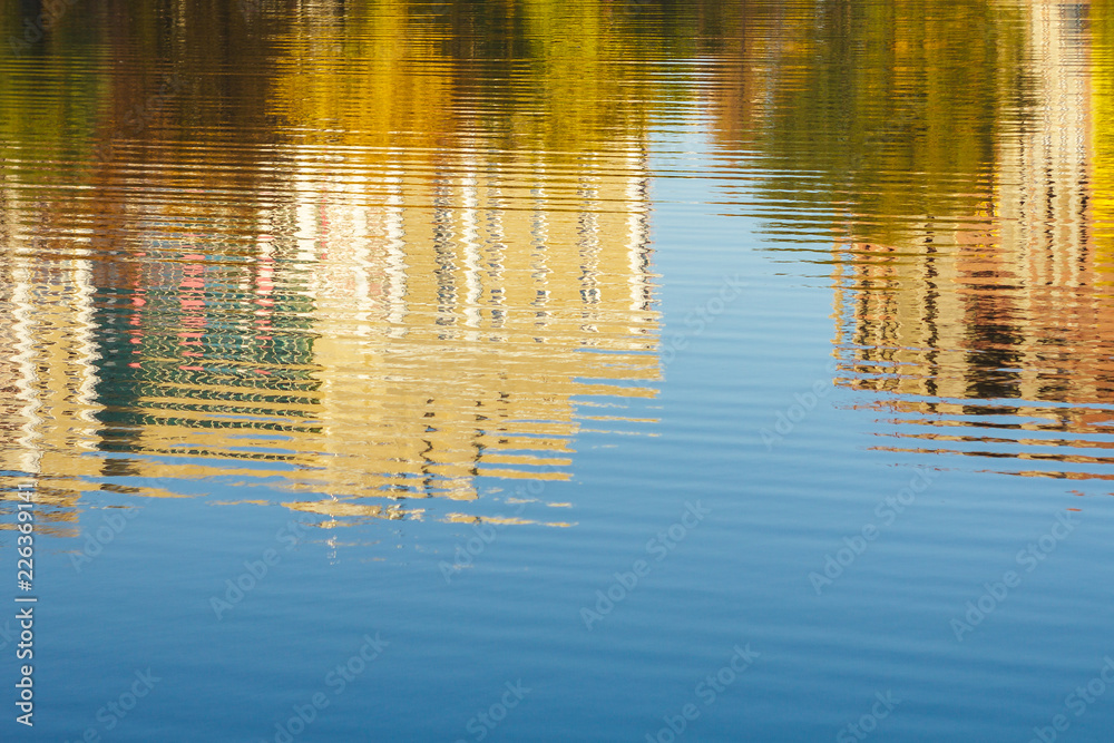Reflection of buildings and trees in water, river, pond, lake in autumn, blue sky, Sunny day Reflection of buildings and trees in water, river, pond, lake in autumn, blue sky, Sunny day