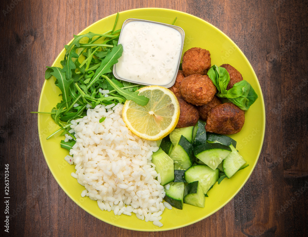 vegan dish with soymeatballs, cucumber,rice and yogurt sauce vegan dish with soymeatballs, cucumber,rice and yogurt sauce