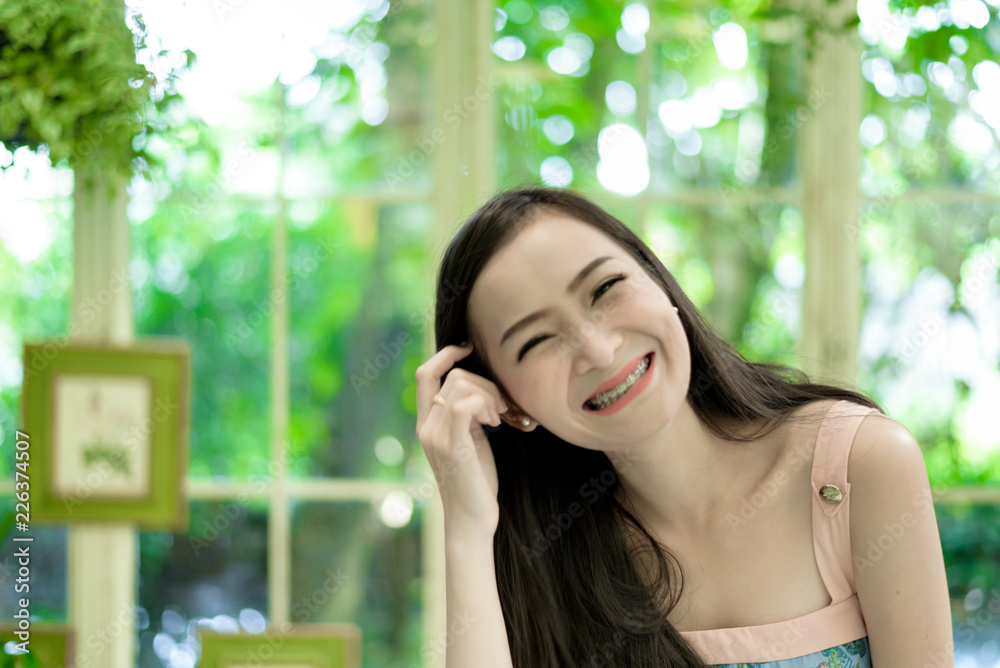 Asian pretty girl has relaxing with happy and smiling at Little Tree Garden cafe, Nakhon Pathom province, Thailand in the morning. Asian pretty girl has relaxing with happy and smiling at Little Tree Garden cafe, Nakhon Pathom province, Thailand in the morning.